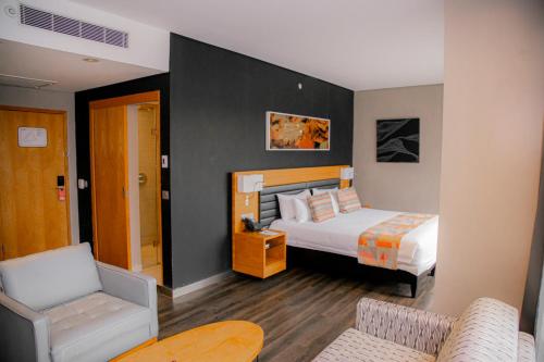 基加利Ubumwe Grande Hotel的配有一张床和一把椅子的酒店客房