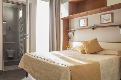 里米尼桑德拉酒店的一间卧室设有一张床和一间浴室。
