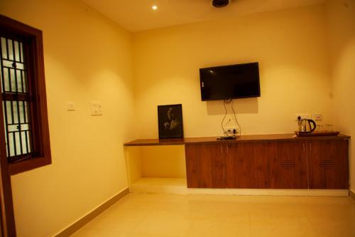 库塔兰WESTN Resorts的一间起居室,在黄色的墙上配有平面电视。