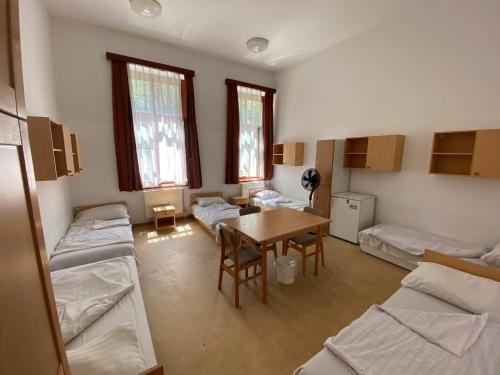 希欧福克希奥旅舍的一间设有几张床和一张桌子的房间和一间团体的房间