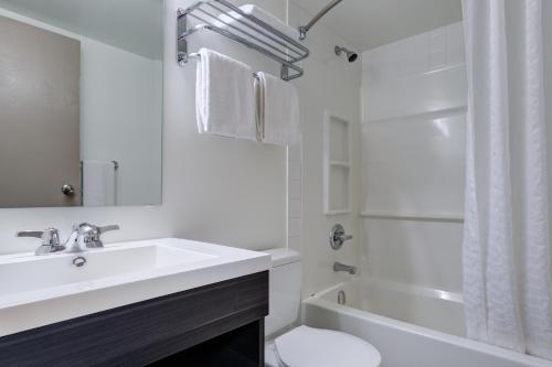 萨斯卡通赫里塔奇酒店&会议中心 - 萨斯卡通的浴室配有盥洗盆、卫生间和浴缸。