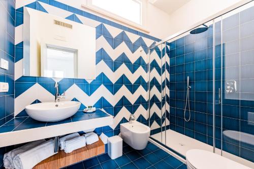 弗洛里La Vigna di Bacco的蓝色瓷砖浴室设有水槽和卫生间