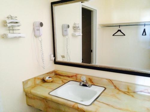 拉斯维加斯Regal Inn Las Vegas New Mexico的一间带大理石水槽和镜子的浴室