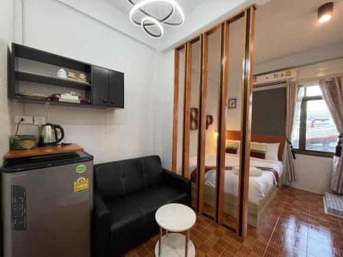 曼谷Acozyposhtel的小房间,配有床和沙发