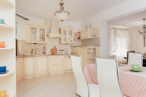梅希莱尼采Zarabie Residence的厨房配有白色橱柜和桌椅