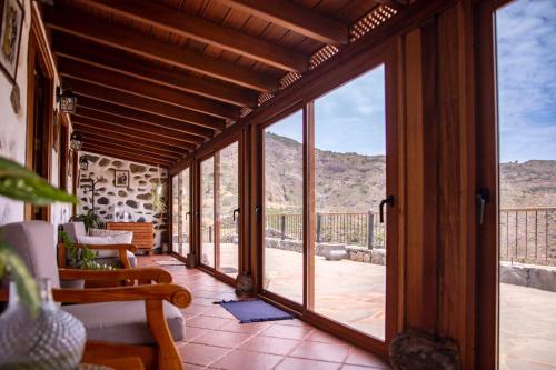 BenchijiguaCasa Rural La Palizada的山地庭院的开放式玻璃门