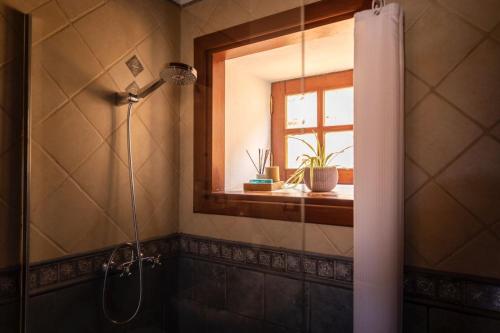 BenchijiguaCasa Rural La Palizada的带淋浴的浴室,配有窗户和浴帘