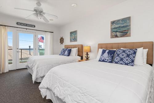 皮斯莫比奇海滨别墅套房酒店的一间卧室配有两张床和吊扇