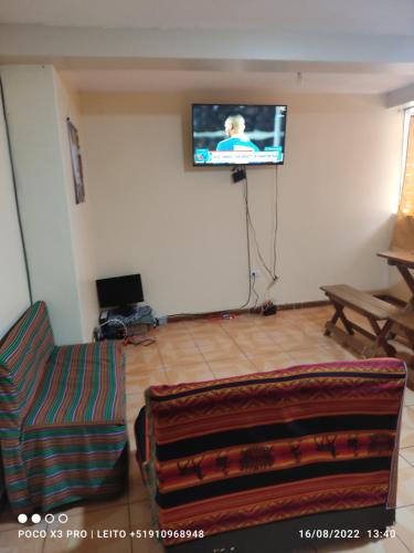 库斯科Anacondor Guests House的客厅配有沙发和墙上的电视