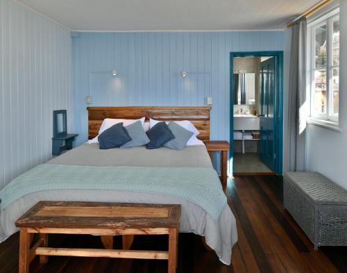 瓦尔帕莱索Hotel Faro Azul Valparaíso Cerro Alegre的一间卧室配有一张带蓝色墙壁的大床