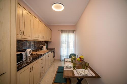 Ágios RókkosZoes Luxury Apartment Corfu的一个带桌子和台面的小厨房