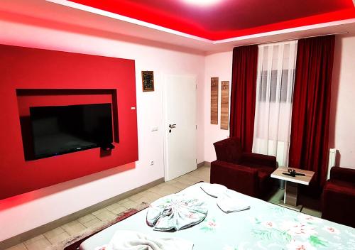 GnjilaneMotel Villa STAR的一间设有红色墙壁、一张床和一把椅子的房间