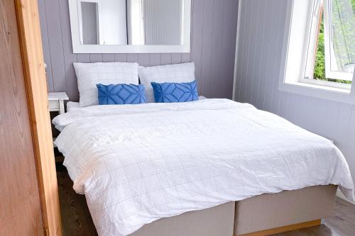 FedaFedafjorden Apartments的一间卧室配有白色床和蓝色枕头