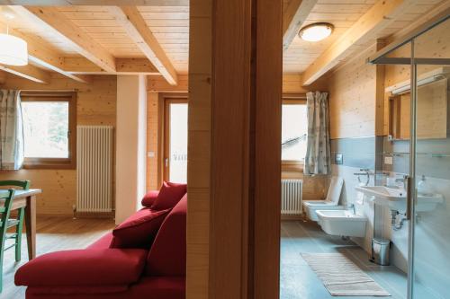 瓦托内切Chalet Gaspard的一间带红色沙发的客厅和一间浴室