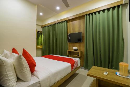 艾哈迈达巴德OYO Hotel Shubham Inn的一间卧室配有床和绿帘