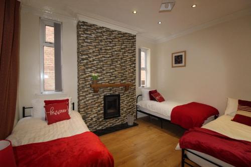 罗瑟勒姆St Ann's House的带两张床和砖砌壁炉的客房