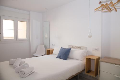 塞维利亚The Nomad Hostel&Pension的卧室配有白色床和毛巾