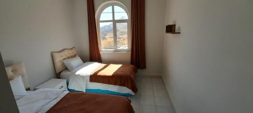 Yandere內姆魯特太陽汽车旅馆的小房间设有两张床和窗户