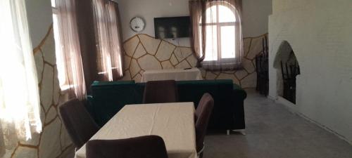 Yandere內姆魯特太陽汽车旅馆的一间设有桌椅的房间和一间带时钟的房间