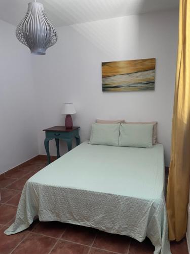 普拉亚布兰卡Villa Rubicon Playa的卧室配有白色的床和桌子