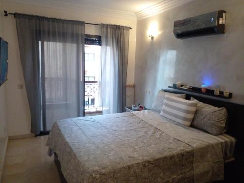 马拉喀什Appartment Jnane Atlas的一间卧室设有一张大床和一个窗户。