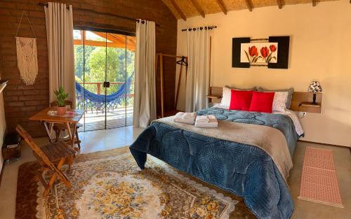 圣安东尼奥-杜皮尼亚尔Chalés Água azul的一间卧室配有一张带红色枕头的大床