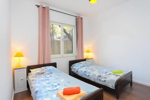 泰斯Apartment Balica Rat 1065a的带窗户的客房内设有两张单人床。