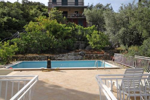 格鲁达Seaside apartments with a swimming pool Molunat, Dubrovnik - 3544的一个带两把椅子的游泳池