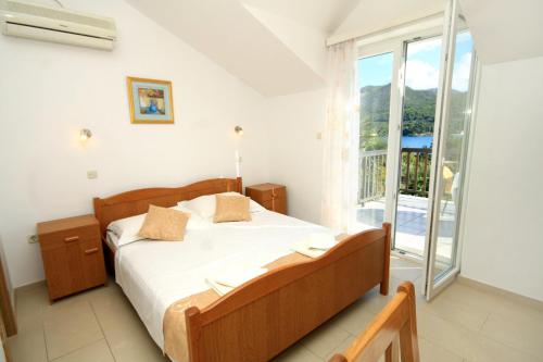 斯拉诺Apartments and rooms with parking space Slano, Dubrovnik - 2159的一间卧室设有一张床和一个大窗户
