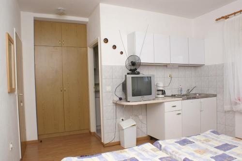 布罗达里卡Apartments with a parking space Brodarica, Sibenik - 4239的白色小厨房配有床和电视