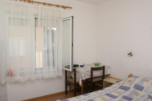 布罗达里卡Apartments with a parking space Brodarica, Sibenik - 4239的一间卧室配有桌子、床和窗户