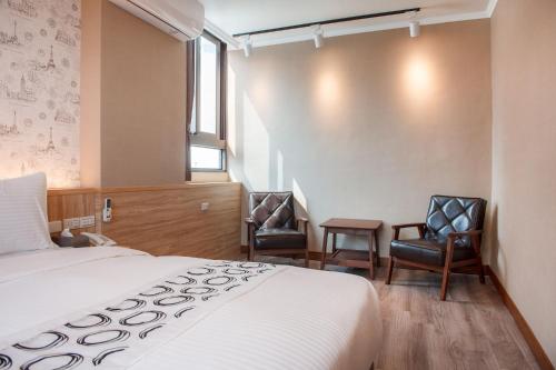 花莲市山水饭店的酒店客房,配有一张床和两把椅子