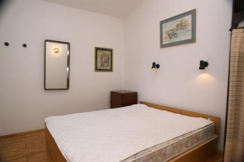 泰斯Apartments by the sea Nemira, Omis - 4277的卧室配有一张床,墙上设有镜子