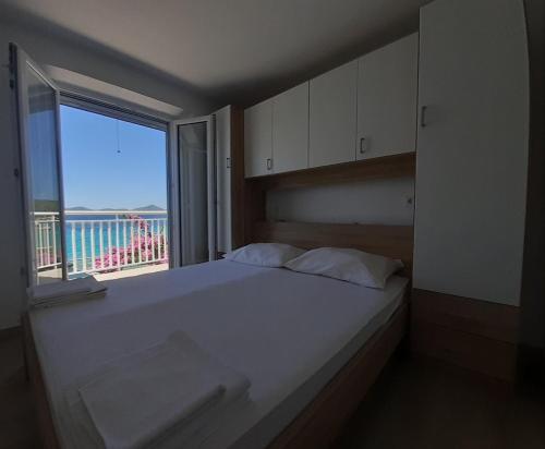 斯拉诺Rooms by the sea Sladjenovici, Dubrovnik - 2161的一间卧室设有一张大床和大窗户