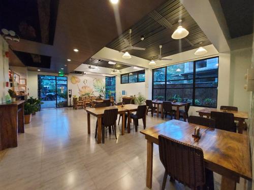 科隆阿卡西亚花园宾馆的餐厅设有木桌、椅子和窗户。