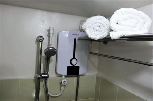 大雅台Ohana at Tagaytay Prime的一间带毛巾和吹风机的浴室,位于架子上