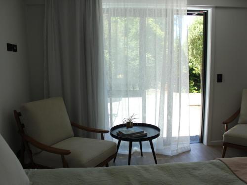玛普瓦māra的一间卧室配有椅子、桌子和窗户