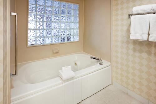 布恩布恩智选假日酒店的带窗户的浴室内的白色浴缸