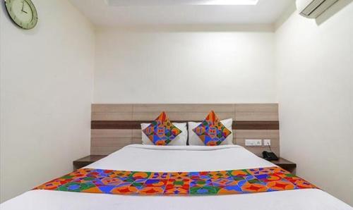 海得拉巴FabHotel Pride Inn Financia的一间卧室配有一张带彩色毯子的床