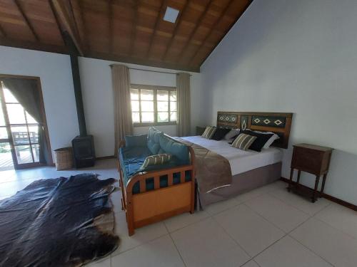 新弗里堡Lumiar Eco Lodge - Chalé Pedra Riscada的一间卧室配有一张床和一张沙发