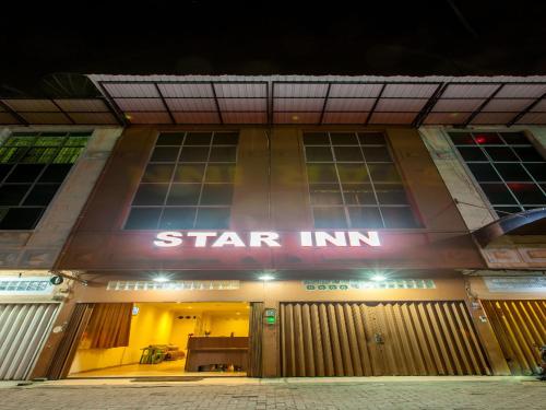 棉兰Star Inn Medan的一座在晚上有星星旅馆标志的建筑