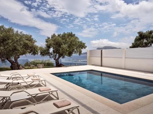 阿克罗蒂Stelle Mare Villa的一座房子旁带躺椅的游泳池