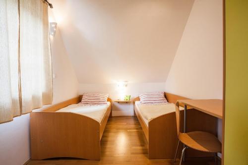 卢布尔雅那奇塔豪斯酒店的小型客房配有两张床和一张桌子。