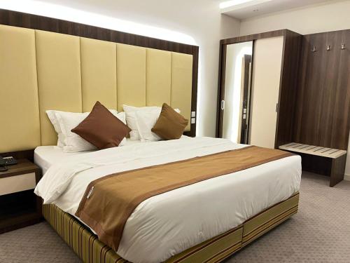 吉赞فندق النزيل الذهبي - Golden Guest Hotel的一间卧室配有一张大床和木制床头板