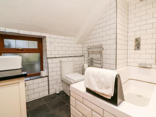 克雷迪顿The Thatched Cottage的带浴缸、卫生间和盥洗盆的浴室
