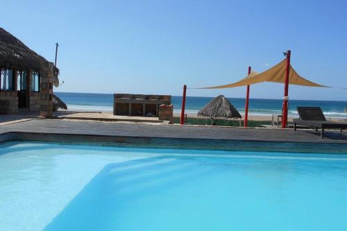 伊尼扬巴内Casa Coco Palmeira的海滩旁的游泳池,带帐篷