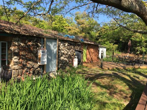 济州市Bongcheon Ville的石头小屋设有门廊和甲板