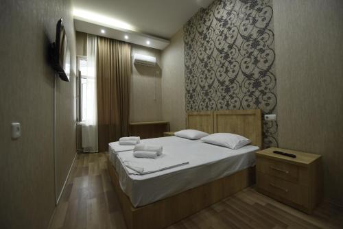 第比利斯Family Hotel Avlabar的一间卧室配有一张带白色床单和镜子的床