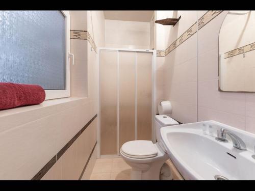 尤尔马拉Valensija - Cute cottage in big yard的白色的浴室设有卫生间和水槽。
