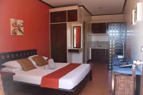 安吉利斯CASA DEL ROQUE的一间设有床铺的卧室,位于一个红色墙壁的房间